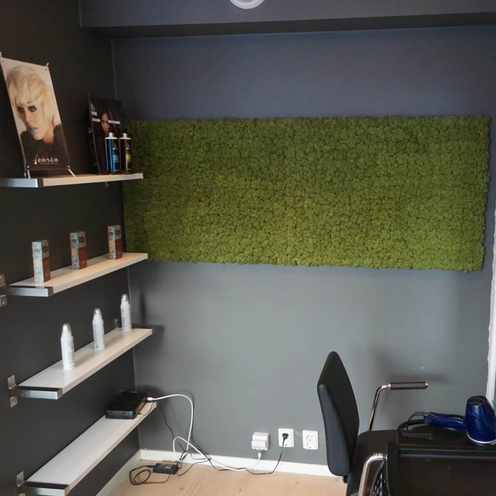 Grønn mose vegg som fondvegg på frisørsalong